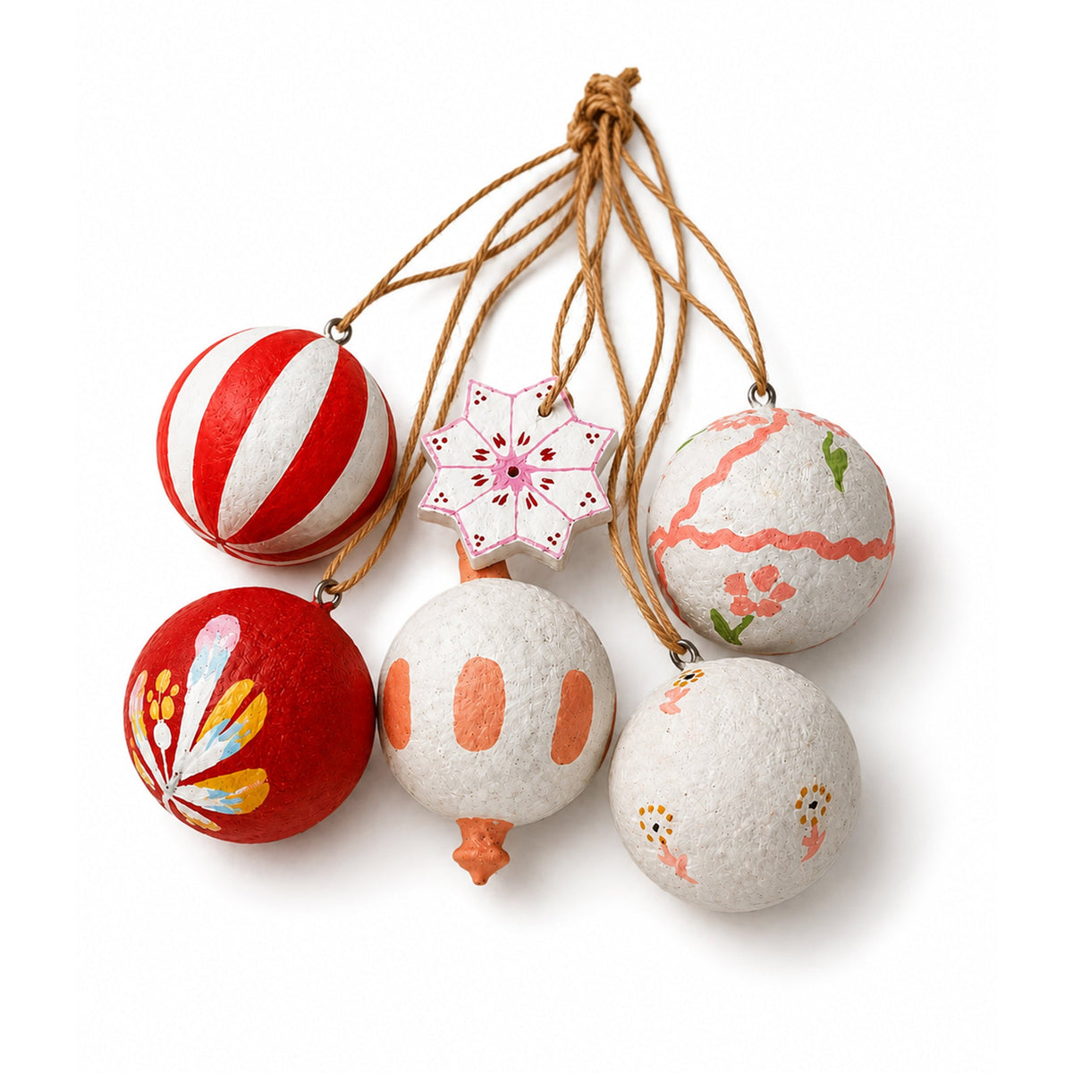 Six red and white painted Christmas decorations, four round baubles, a drop and a star, with their twine loops gathered together on a white background