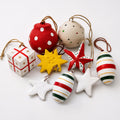 Handmade paper mache Christmas ornament set 9 pieces red green gold stars baubles gift box on white background