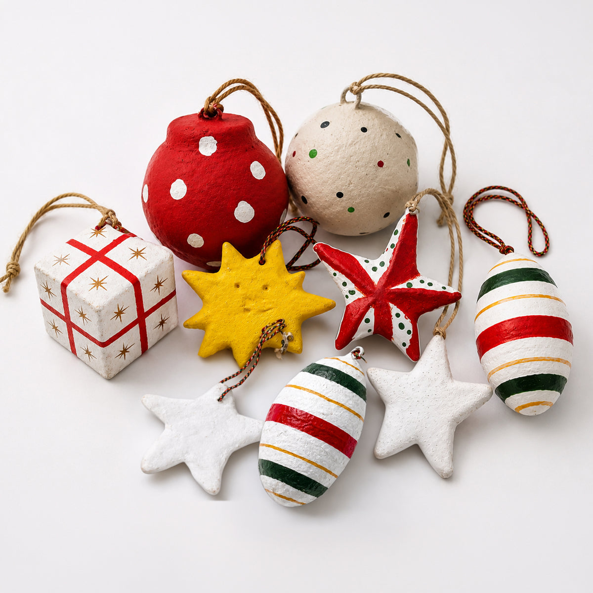 Handmade paper mache Christmas ornament set 9 pieces red green gold stars baubles gift box on white background