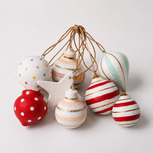 Set of handmade pastel paper mache Christmas baubles with candy stripes and star ornament