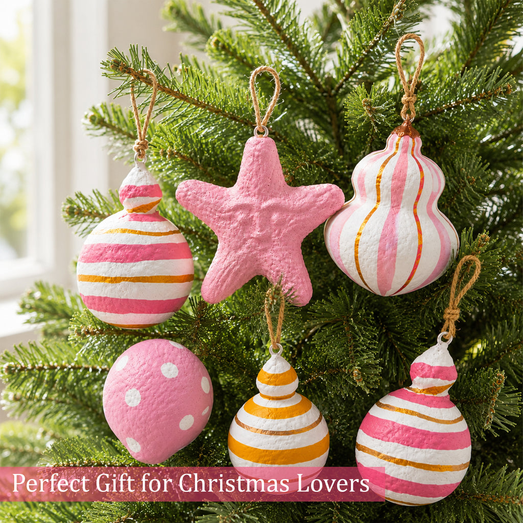 Pink and gold handmade Christmas ornaments hanging on a festive tree