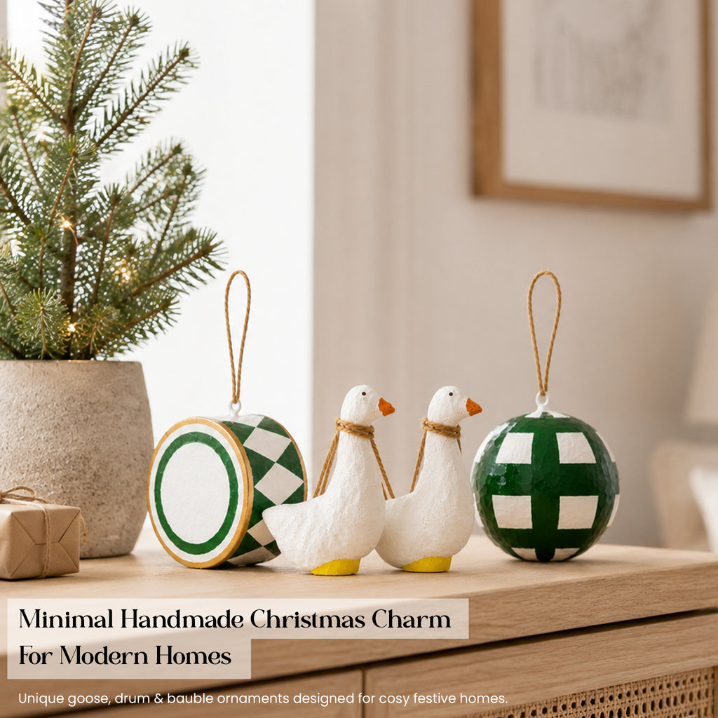 Green and white Scandi handmade paper mache Christmas ornament set displayed on wooden sideboard with mini tree and gifts