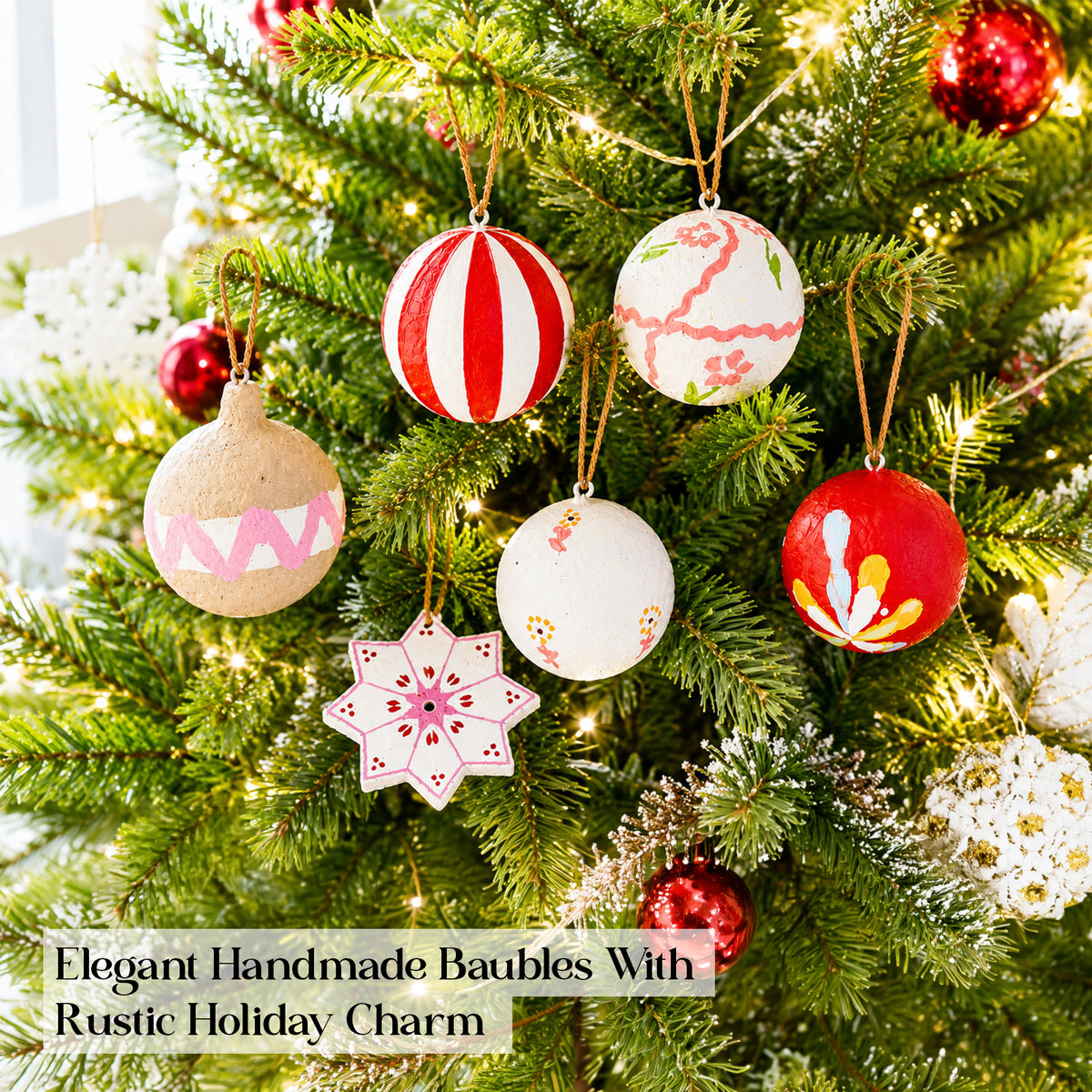 Artisan Christmas baubles hanging on decorated Christmas tree with fairy lights
