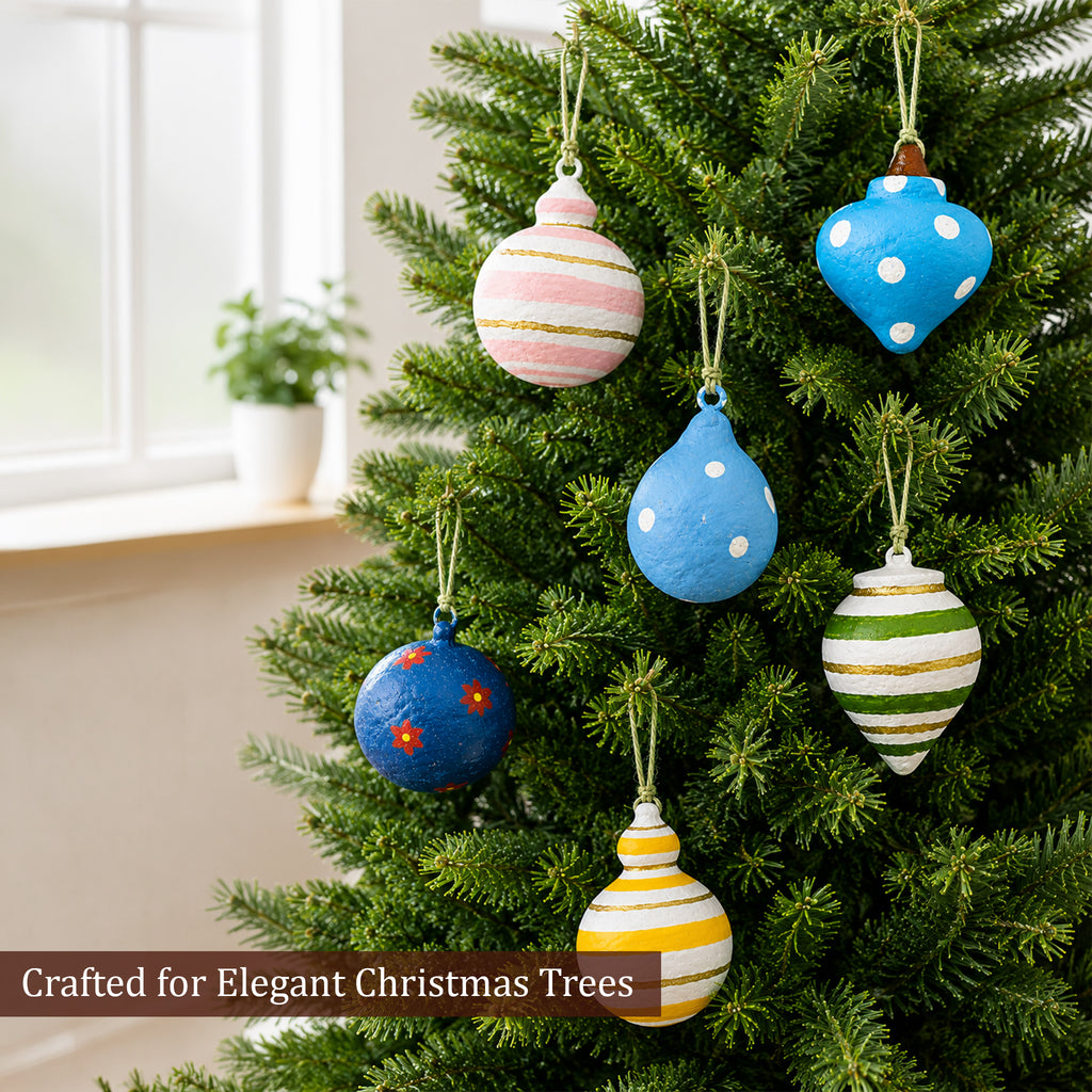 Colourful paper mache Christmas baubles hanging on a festive tree