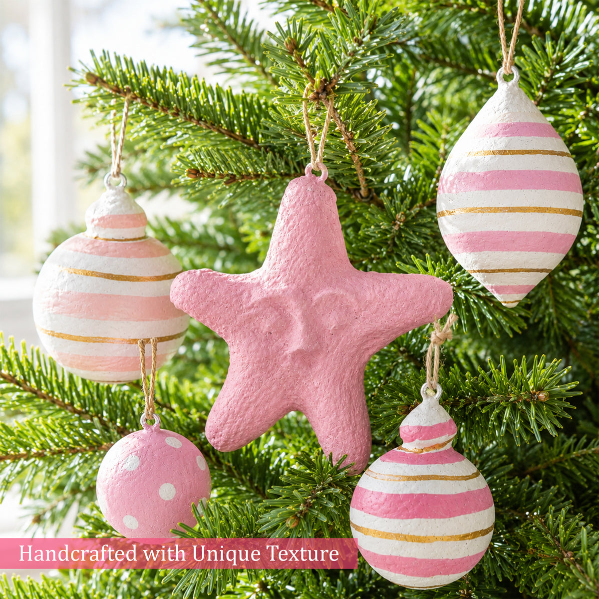 Pink storybook Christmas ornaments hanging on a festive tree