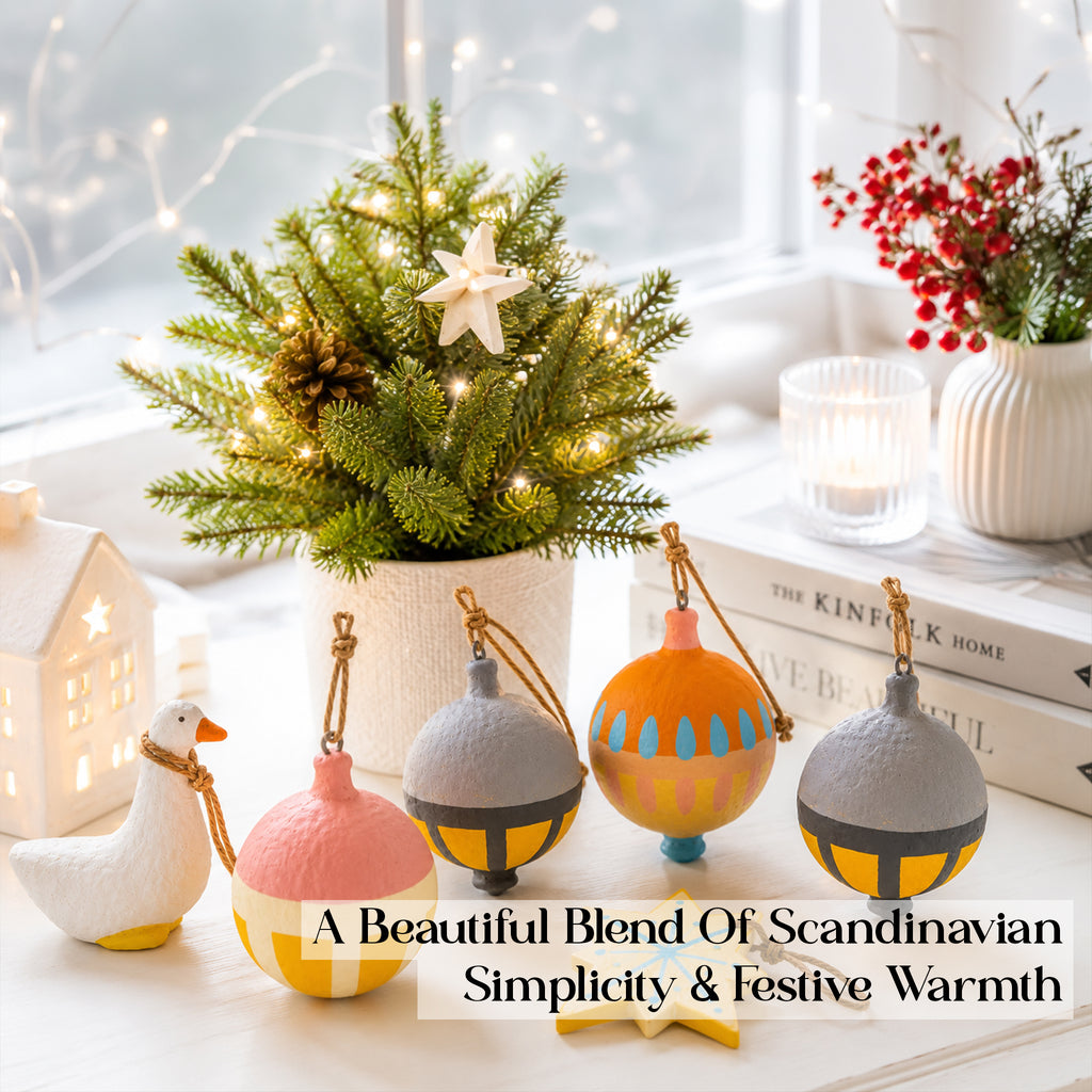 Scandi handmade Christmas ornament set styled on windowsill with small tree and fairy lights – orange grey mustard papier mâché baubles UK
