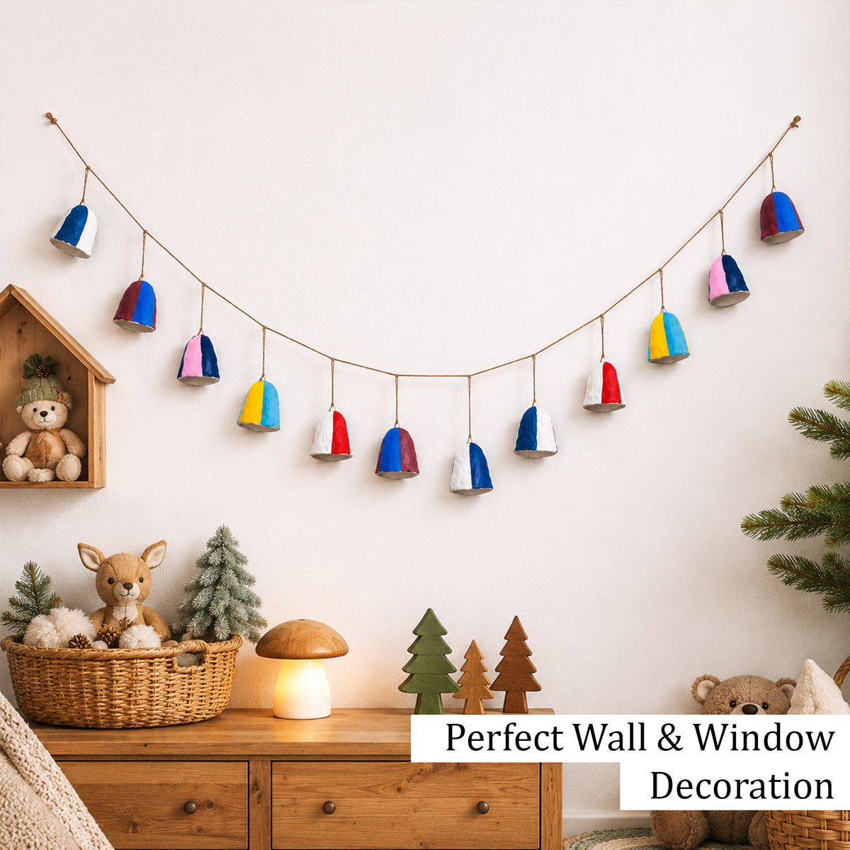 Handmade multicolour paper mache bell garland hung as wall decoration above children's bedroom dresser