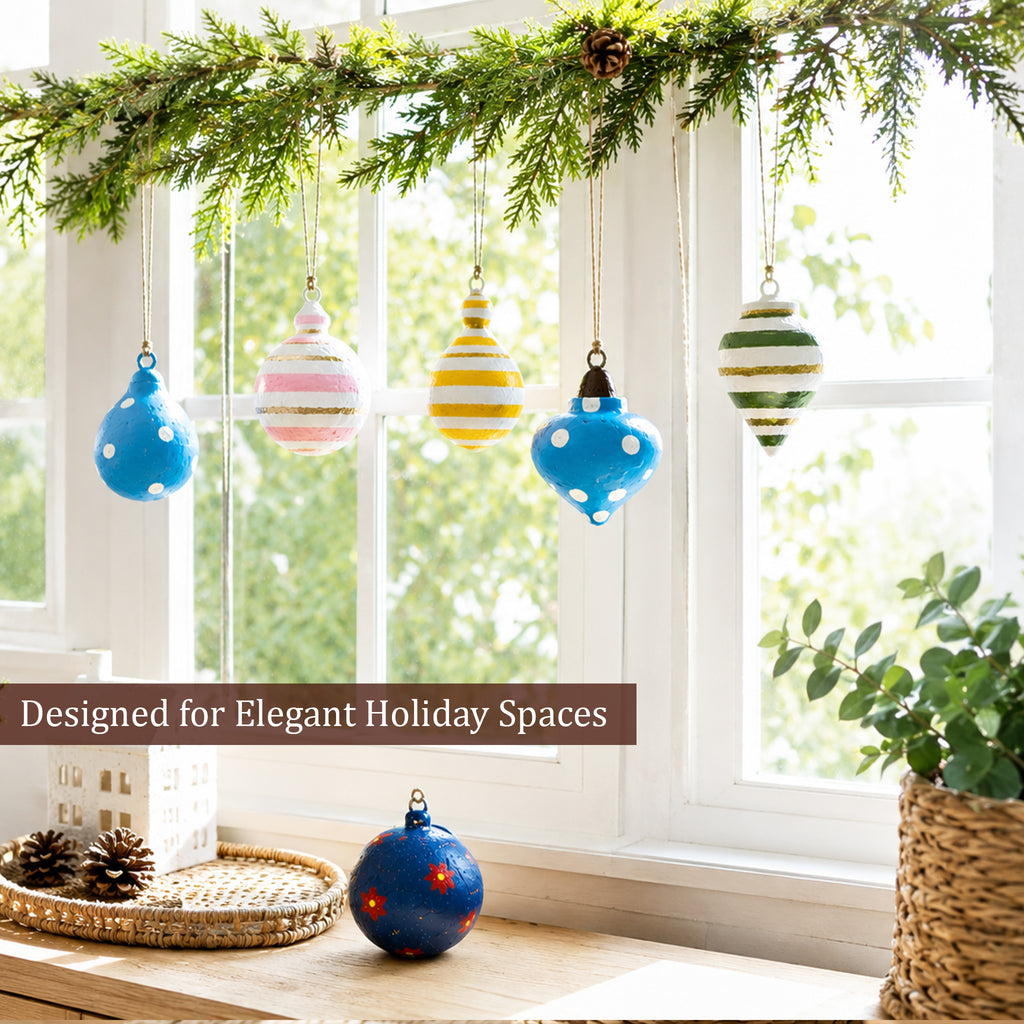 Colourful hanging Christmas baubles styled near a bright window