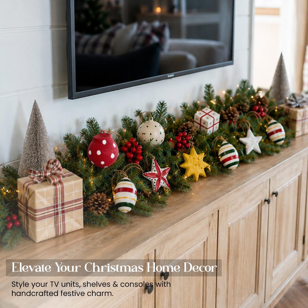 Handmade paper mache Christmas ornament set styled along sideboard console table Christmas pine garland UK