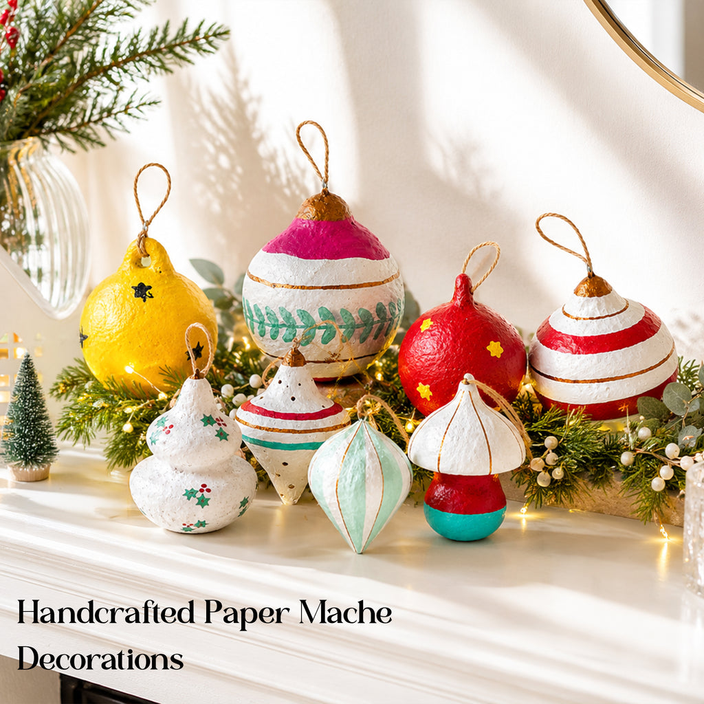 Handcrafted paper mache Christmas decorations styled on a mantel with festive lights