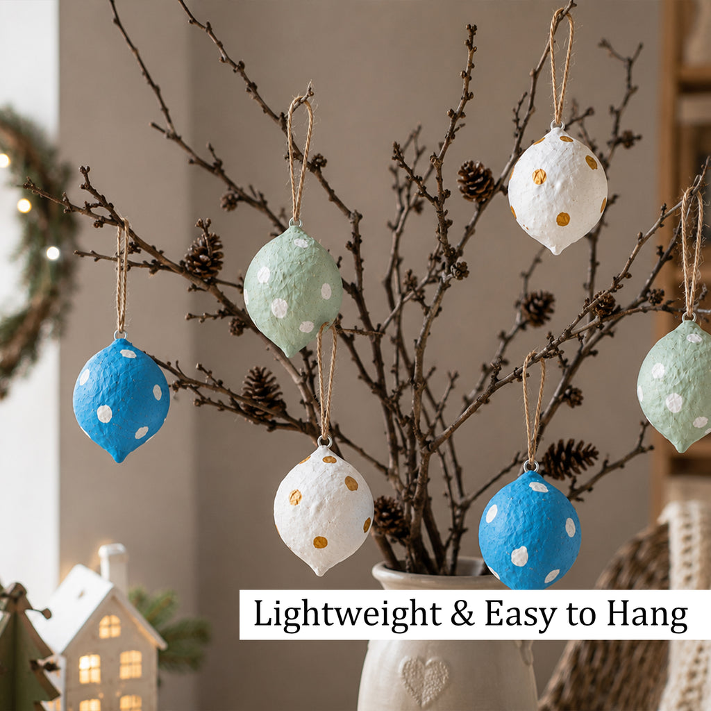 Lightweight paper mache ornaments hanging from decorative branches