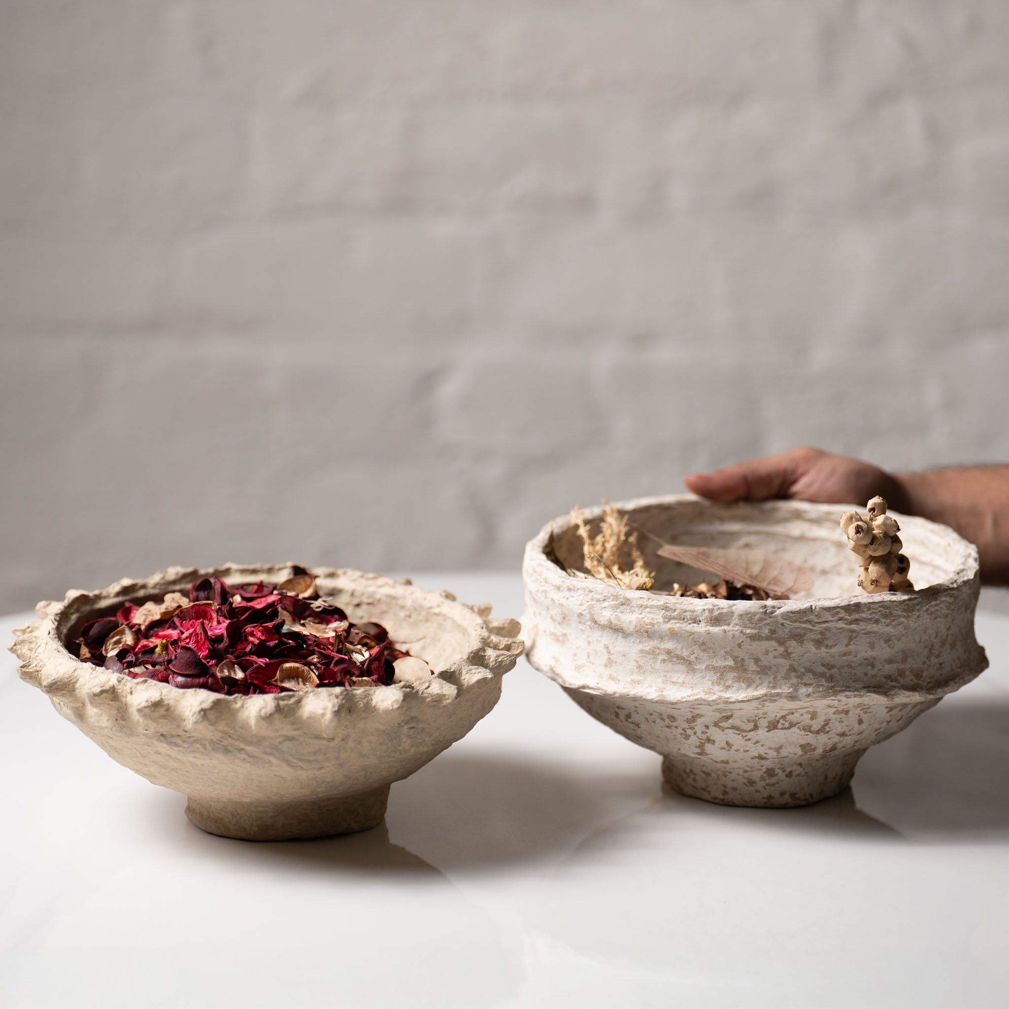 Rustic paper mache bowl filled with dried potpourri in natural beige tones