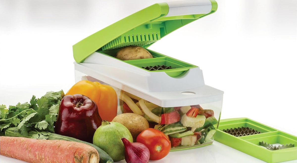 Chopper with the green lid raised, showing the comb under the lid, a potato on the dicing grid and chopped vegetables inside