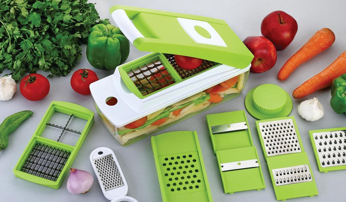 Dicing tray seated in the white frame with a tomato on the grid, and the second tray, slicer board and inserts beside it